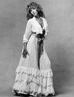 a black and white photo of a woman wearing a dress with ruffles on it