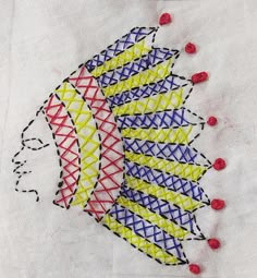 a piece of art that looks like an embroidered fish with red and blue thread on it