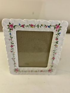 a small white frame with flowers on it