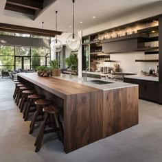 a large kitchen with an island counter and bar stools in the middle of it