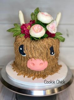 a cake decorated to look like a cow with flowers on its head and horns sticking out