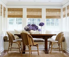 a dining room table with chairs and flowers on it