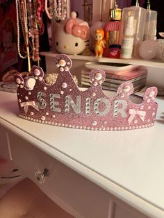 a pink princess crown sitting on top of a white desk