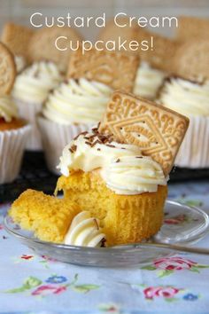 some cupcakes with cream frosting and cookies on top are sitting on a plate