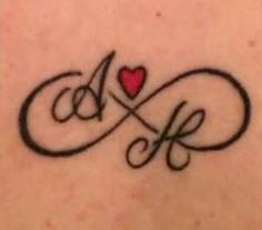 the back of a woman's shoulder with an infinite symbol and heart tattoo on it