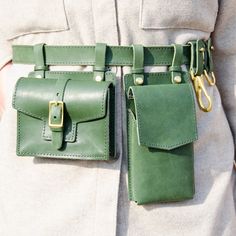 a person wearing a green belt with two leather pouches