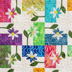 a colorful quilt with flowers and leaves on it