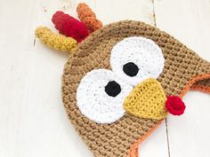 a crocheted turkey hat is laying on the floor with its eyes wide open