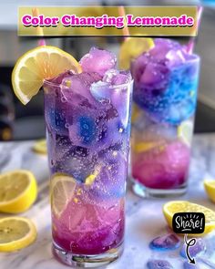 two glasses filled with ice and lemons on top of a table next to sliced lemons