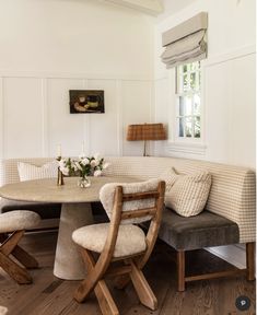 a table and chairs in a room with white walls