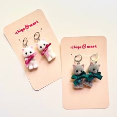 two keychains with cats on them sitting next to each other in front of a card