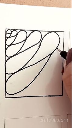 someone is drawing something with black ink on white paper