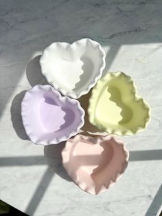 four different colored bowls sitting on top of a table