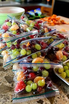 grapes and oranges are wrapped in plastic bags