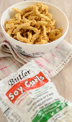 a white bowl filled with butter soy curls next to a bag of salt and pepper