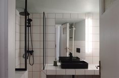 a bathroom with a sink, mirror and shower head