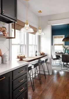 a kitchen with wooden floors and black cabinets