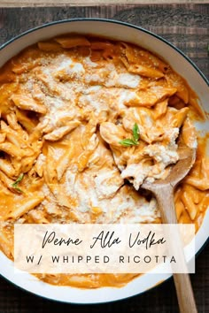 a bowl filled with pasta and cheese on top of a wooden table