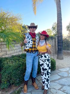 a man and woman dressed up as toy story characters posing in front of a palm tree