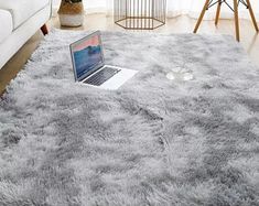 a laptop computer sitting on top of a shaggy rug