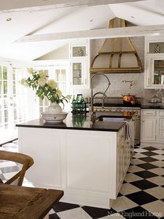 a kitchen with black and white checkered flooring on the walls, an island in the middle