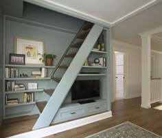 a living room filled with furniture and a flat screen tv on top of a book shelf