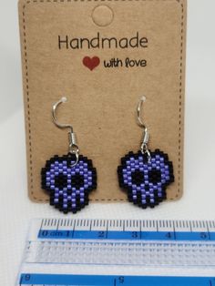 a pair of earrings made out of pixellated beads with a heart on each earring