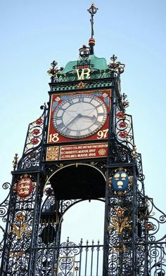 an ornate clock tower with wrought iron fencing