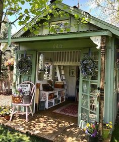 a small green shed sitting on top of a lush green field