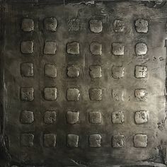 an old metal plate with squares and dots on the surface is shown in this image