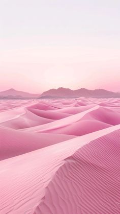 pink sand dunes with mountains in the distance