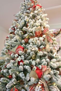 a decorated christmas tree with red and white bows