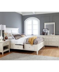 a bedroom with gray walls and white furniture