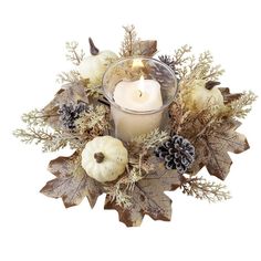 a candle that is sitting next to some leaves and pumpkins on a table with pine cones