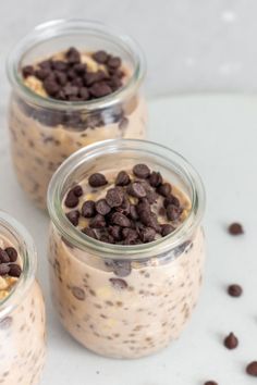 three jars filled with chocolate chips and oatmeal on top of a table