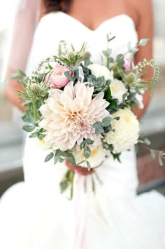 a bridal holding a bouquet of white and pink flowers