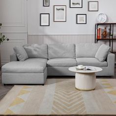 a living room with a sectional couch, coffee table and bookshelf on the wall