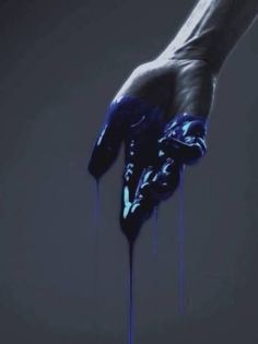 a person's hand with blue paint dripping from it