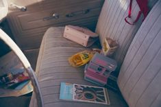 the interior of an old car with magazines and other items on the seat back area