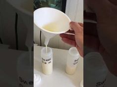 someone is pouring milk into two small cups