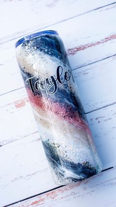 a tumbler cup with the word tryle on it sitting on a white wooden surface