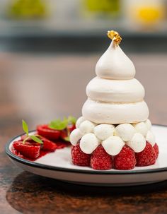 a plate topped with whipped cream and raspberries