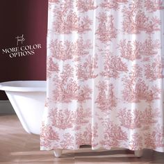 a bath tub sitting next to a shower curtain with pink and white designs on it