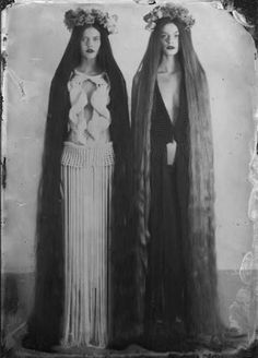 two women with long hair standing next to each other wearing veils and headdress