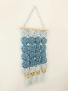 a crocheted blue and white wall hanging with tassels