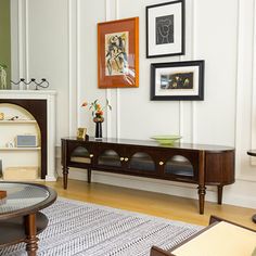 a living room filled with furniture and framed pictures on the wall above a fire place