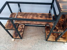 a set of three wooden benches sitting next to each other on top of a cement floor