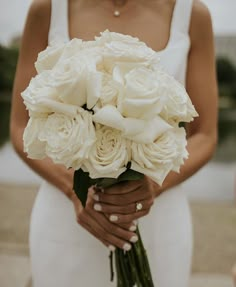 a woman holding a bouquet of white flowers