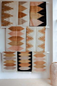 an arrangement of native rugs hanging on the wall