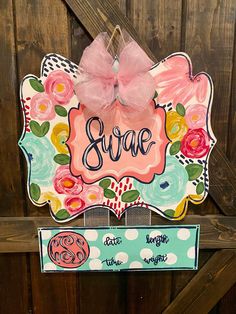 a wooden sign with flowers on it and the name sara written in cursive writing